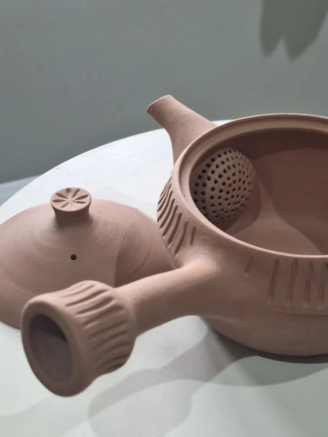 Detalhes dos nossos bules kyusus em produção. Fizemos alguns protótipos desse tipo de bule de chá, anteriormente em porcelana. Como é uma massa bem peculiar e que reage diferentemente das massas cerâmicas, ela pode se deformar facilmente em alguns processos devido às variáveis de queima, modelagem e características, então para produções em pequena escala como a nossa, não me senti feliz com as consideradas normais perdas em uma produção. Talvez para produções em grande escala, com uma estrutura maior, seja menos doloroso emocionalmente e financeiramente. São peças adoráveis de fazer, de se perder no tempo. Agora, produzidos com uma massa cerâmica, esperamos ver resultados mais confortantes. Acompanhem....
Details of our kyusu teapots in production. We made some prototypes of this type of teapot, previously in porcelain. Because it's a very peculiar material that reacts differently from ceramic materials, it can easily deform in some processes due to the variables of firing, shaping, and characteristics. So, for small-scale productions like ours, I wasn't happy with the normal losses. Perhaps for large-scale productions, with a larger structure, it would be less painful emotionally and financially. They are lovely pieces to make, to lose in time. Now, produced with a ceramic material, we hope to see more comforting results. Stay tuned.#designartesanal #ceramicaartesanal #teapottery #ceramicart  #cerimoniadocha #chasespeciais #chasbrasileiros #designproduct #teainstagram #chalovers #tealovers #teaceremony #brazilianart #teaware #thewayoftea #teahouse #braziliandesign #camelliasinensis #teapot  #teatime #tableware #kyusuteapot #senchatea #shiboridashikasa #gyokurotea #teaculture #teaparty #teacommunity #teaexperience #fernandasoaresceramicas