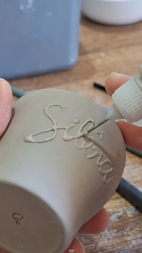 Ontem eu estava praticando algumas alternativas para escrever na cerâmica, e durante os testes essa técnica que utilizei se materializou de forma espontânea me causando bastante entusiasmo! Achei extraordinário como nossa mente funciona. Aprendo facilmente com a observação, e durante esse fluxo me lembrei de onde minha mente resgatou essa técnica. O engraçado é que eu havia pensado nela, mas a descartei porque pensei de acordo com o registro que eu tinha em mente. Quando a técnica fluiu naturalmente no meu objetivo eu sorri pensando no quão bom e apraz é deixar nossa mente livre. Testar, errar, testar, acertar, testar, descobrir, testar, ousar, testar, expandir....
Yesterday I was practicing some alternatives for writing on ceramics, and during the tests, this technique I used materialized spontaneously, making me very excited! I found it extraordinary how our minds work. I learn easily through observation, and during this flow, I remembered where my mind had retrieved this technique. The funny thing is, I had thought of it, but discarded it because I thought along the lines of the register I had in mind. When the technique flowed naturally into my objective, I smiled, thinking about how good and pleasurable it is to let our minds run wild. Test, fail, test, get it right, test, discover, test, dare, test, expand.#designartesanal #ceramicaartesanal #teapottery #ceramicart  #cerimoniadocha #chasespeciais #chasbrasileiros #cozytime #teainstagram #chalovers #tealovers #teaceremony #brazilianart #teaware #thewayoftea #teahouse #braziliandesign #camelliasinensis #teapot  #teatime #tableware #bules #claytechniques #productdesign  #coffeetıme #teaculture #teaparty #teacommunity #teaexperience #fernandasoaresceramicas